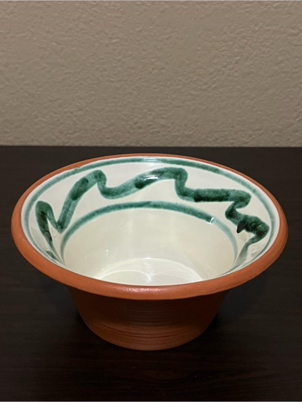 Redware Spanish Terracotta pottery bowl w/ white center & green squiggly lines.